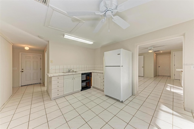 kitchen with sink, white cabinetry, light tile patterned floors, and white fridge