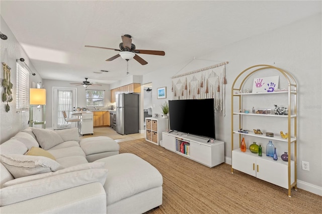 living room featuring a ceiling fan and baseboards