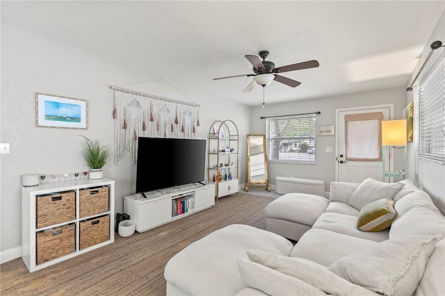 living room with a ceiling fan and baseboards