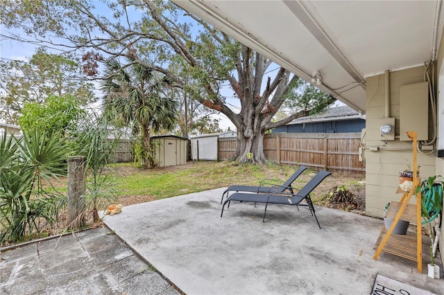 view of patio / terrace featuring a storage shed, a fenced backyard, and an outbuilding