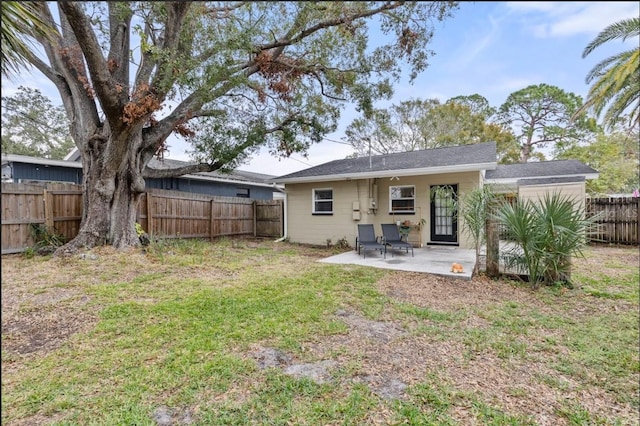 back of house with a fenced backyard, a patio, and a yard