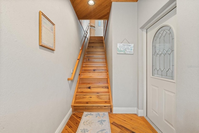 stairs with hardwood / wood-style flooring and wood ceiling