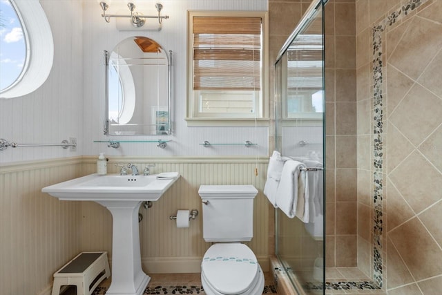 bathroom featuring toilet, tile patterned flooring, sink, and a shower with shower door