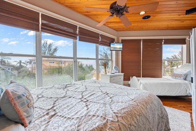 bedroom with ceiling fan, hardwood / wood-style flooring, and wooden ceiling