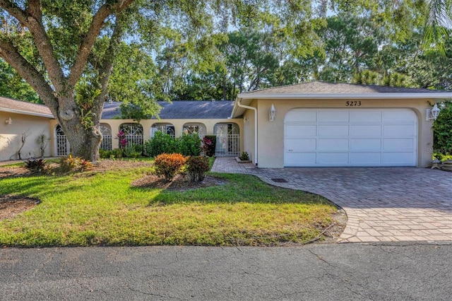 ranch-style house featuring a garage and a front yard