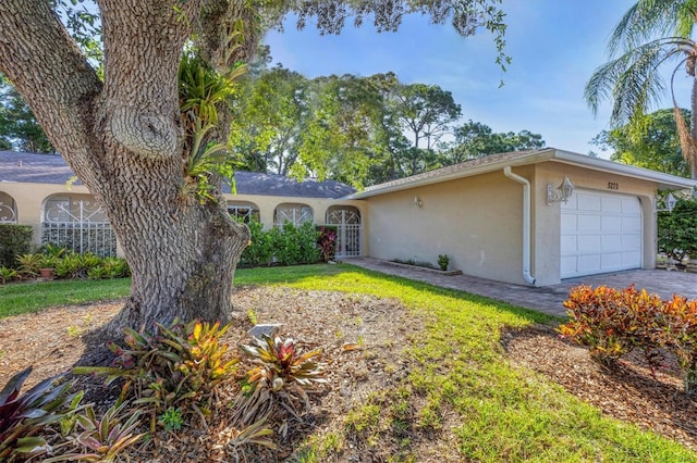 ranch-style home featuring a garage and a front lawn