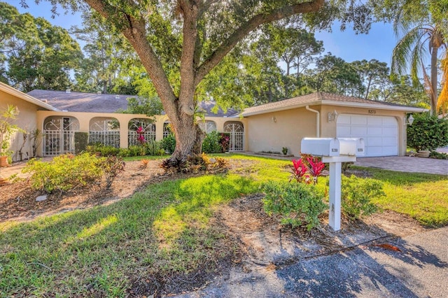 single story home featuring a front lawn and a garage