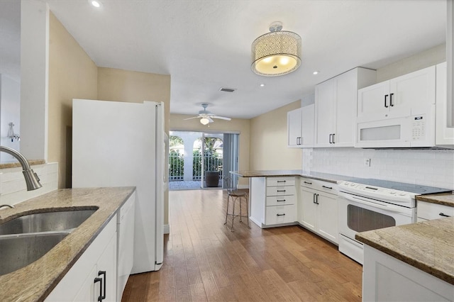 kitchen with white cabinets, sink, and white appliances