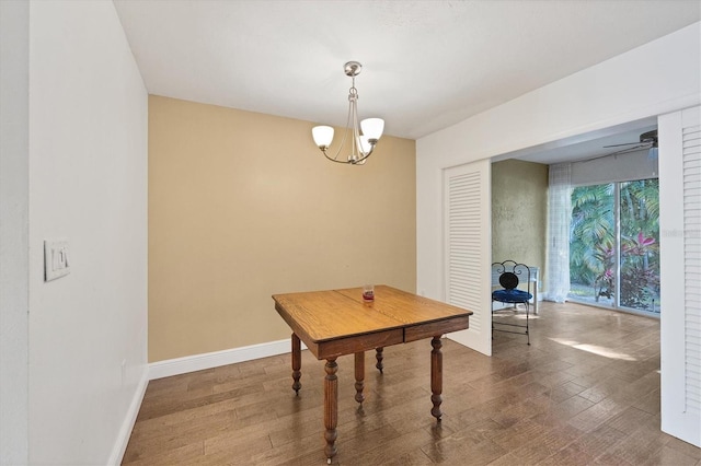 dining area featuring ceiling fan with notable chandelier and hardwood / wood-style floors