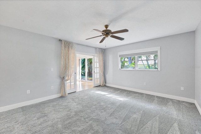 carpeted spare room with ceiling fan and french doors