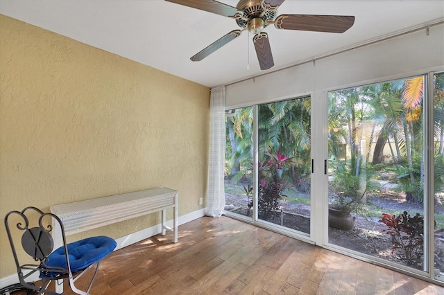 unfurnished sunroom with ceiling fan