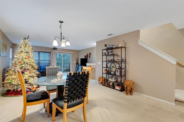 dining area featuring light carpet and a notable chandelier