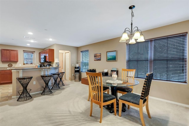 dining area featuring an inviting chandelier and light colored carpet