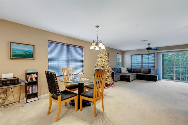 carpeted dining room featuring a chandelier