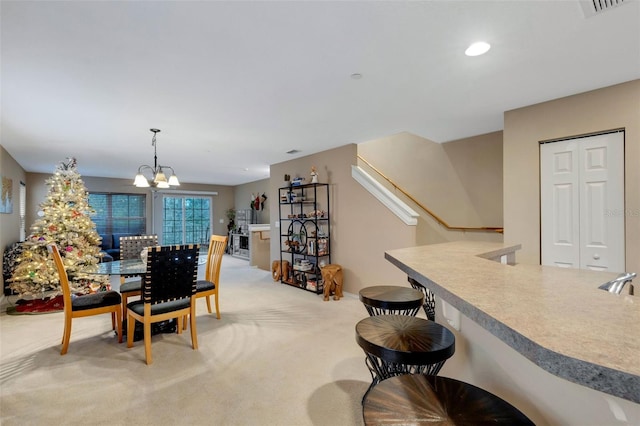 dining area with light carpet and a notable chandelier