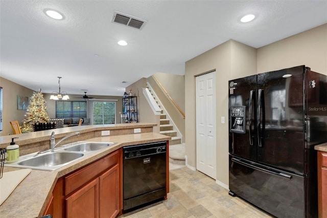 kitchen with decorative light fixtures, sink, and black appliances