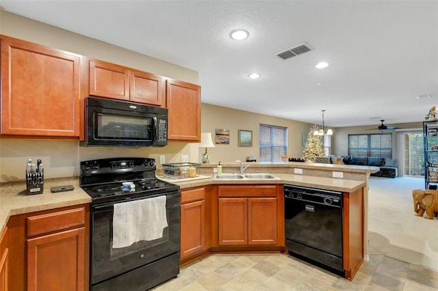 kitchen featuring sink, decorative light fixtures, kitchen peninsula, ceiling fan with notable chandelier, and black appliances