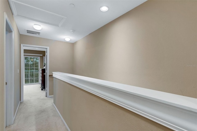 hallway featuring light colored carpet