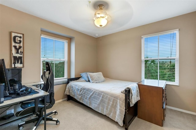 carpeted bedroom with multiple windows and ceiling fan