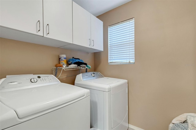 laundry area with cabinets and washer and clothes dryer