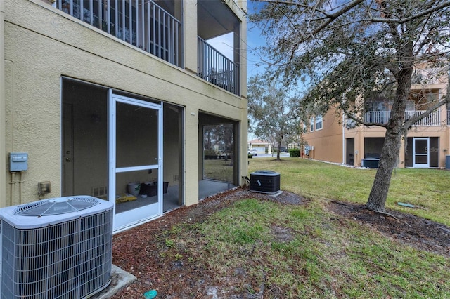 view of yard with a sunroom and central air condition unit