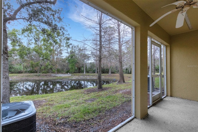 view of yard with a water view, cooling unit, and ceiling fan