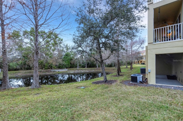 view of yard featuring central air condition unit and a water view