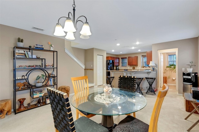 carpeted dining space featuring a notable chandelier