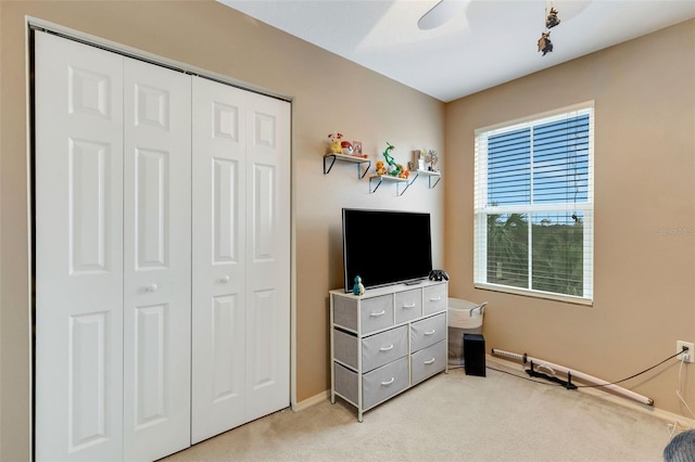 bedroom featuring ceiling fan, light colored carpet, and a closet