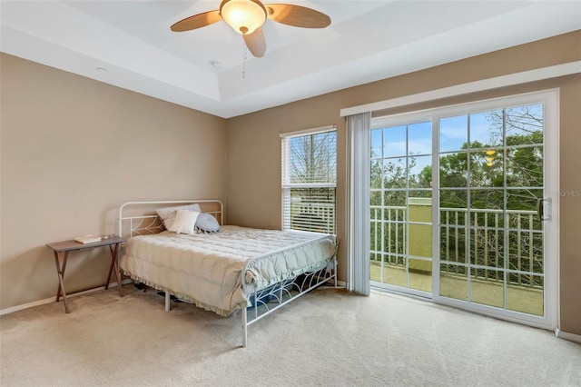 bedroom featuring a raised ceiling, carpet, access to outside, and ceiling fan