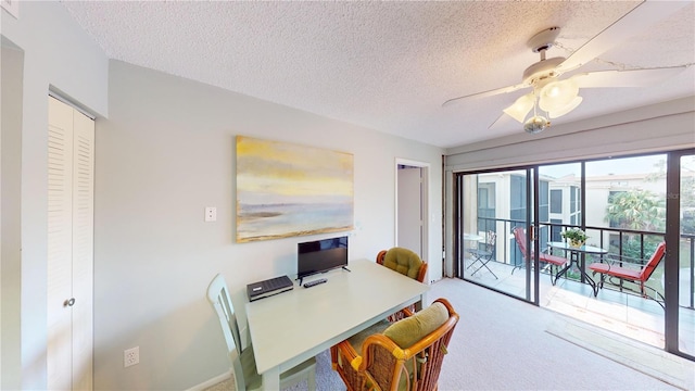 carpeted dining room featuring a textured ceiling, ceiling fan, and a healthy amount of sunlight