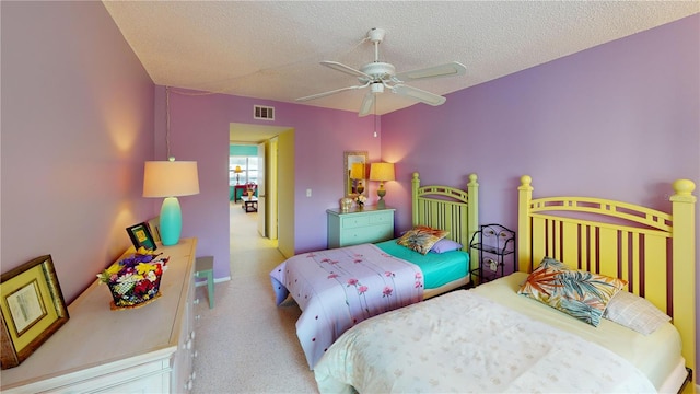 bedroom featuring a textured ceiling, ceiling fan, and light colored carpet