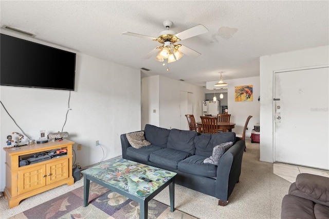 living room featuring ceiling fan and a textured ceiling