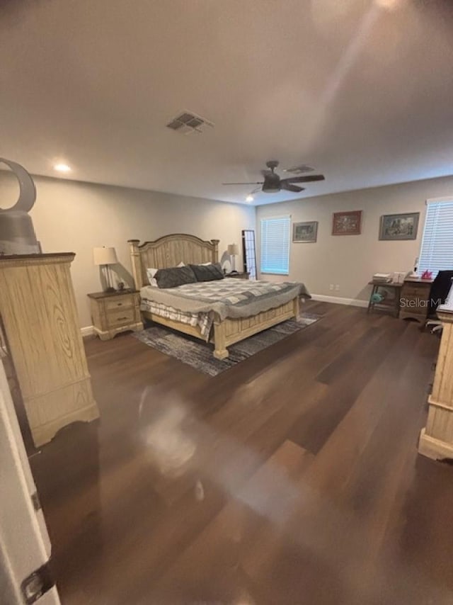 bedroom with visible vents, a ceiling fan, baseboards, and dark wood-style flooring