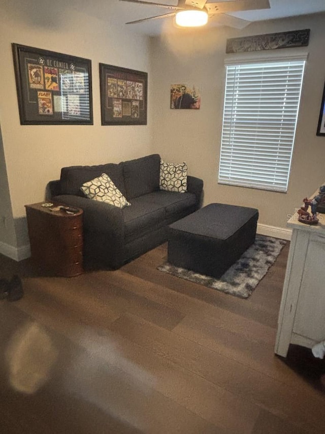 living room with baseboards, ceiling fan, and wood finished floors