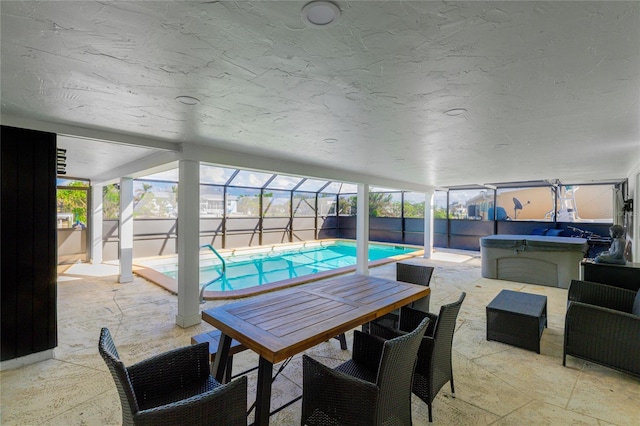 view of patio with a lanai and a pool with hot tub