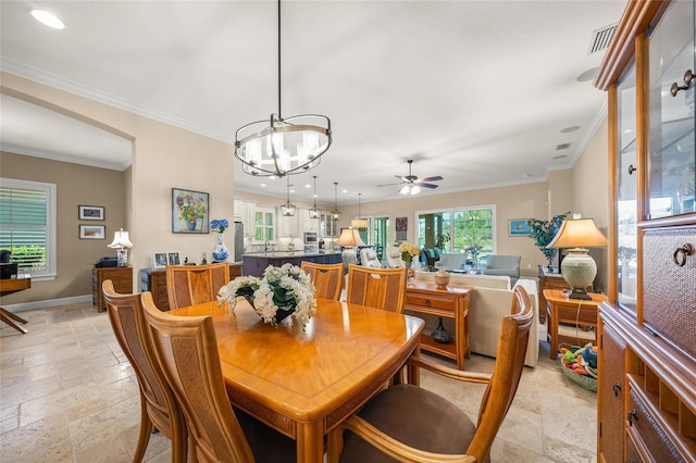 dining room with ceiling fan with notable chandelier and ornamental molding