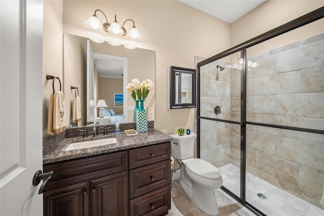 bathroom with a shower with door, vanity, ornamental molding, and toilet