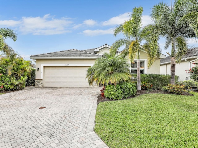 view of front of property featuring a garage, a front lawn, decorative driveway, and stucco siding