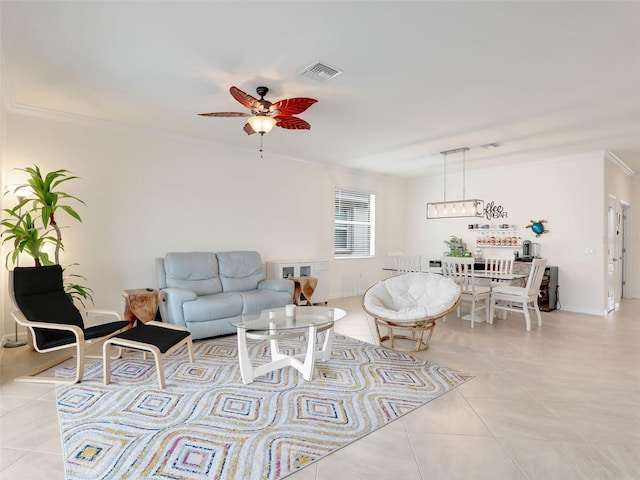 living room with ornamental molding, light tile patterned flooring, visible vents, and a ceiling fan