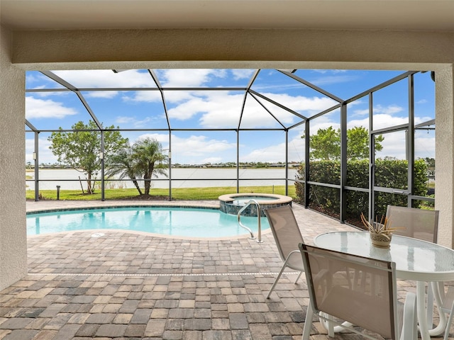 view of pool featuring glass enclosure, a patio area, a water view, and a pool with connected hot tub