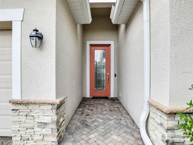 doorway to property featuring stucco siding