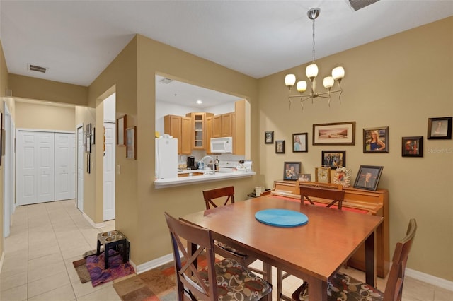 tiled dining room with an inviting chandelier