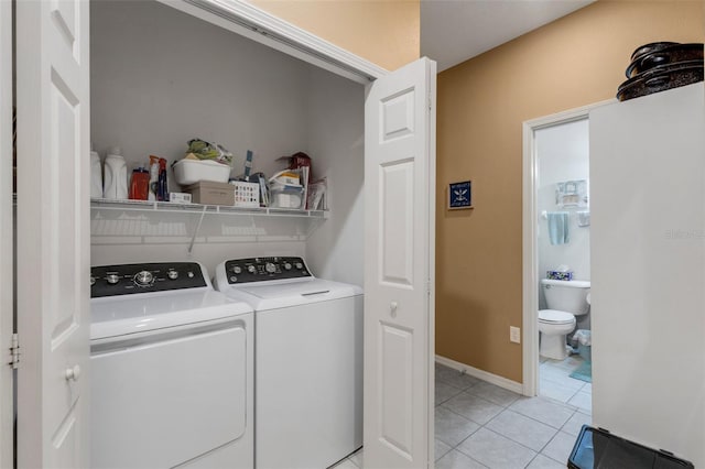 washroom with light tile patterned floors and washer and clothes dryer