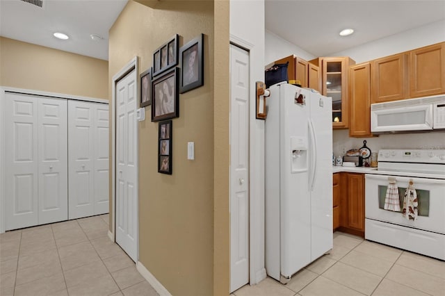 kitchen with white appliances and light tile patterned flooring