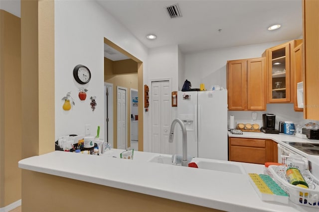 kitchen with sink, white appliances, and kitchen peninsula