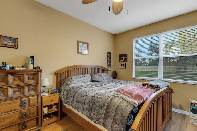 bedroom with ceiling fan, light hardwood / wood-style floors, and multiple windows