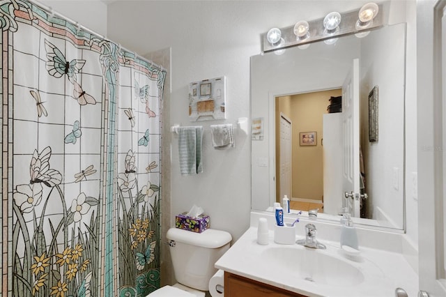 bathroom featuring toilet, walk in shower, and vanity