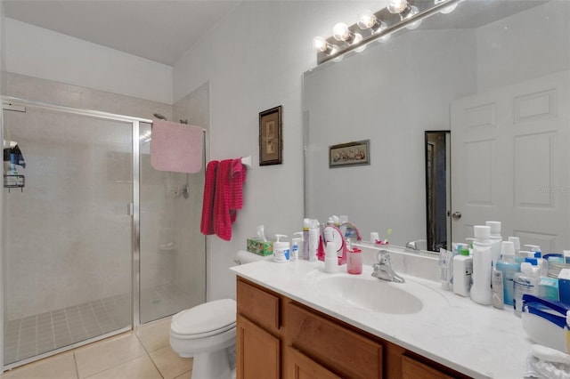 bathroom with vanity, toilet, tile patterned floors, and a shower with door