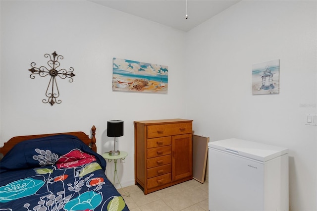 bedroom with fridge and light tile patterned flooring